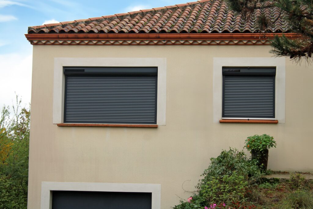 Photo de l'extérieur d'une maison avec des volets roulants fermées dans la banlieue de Rouen